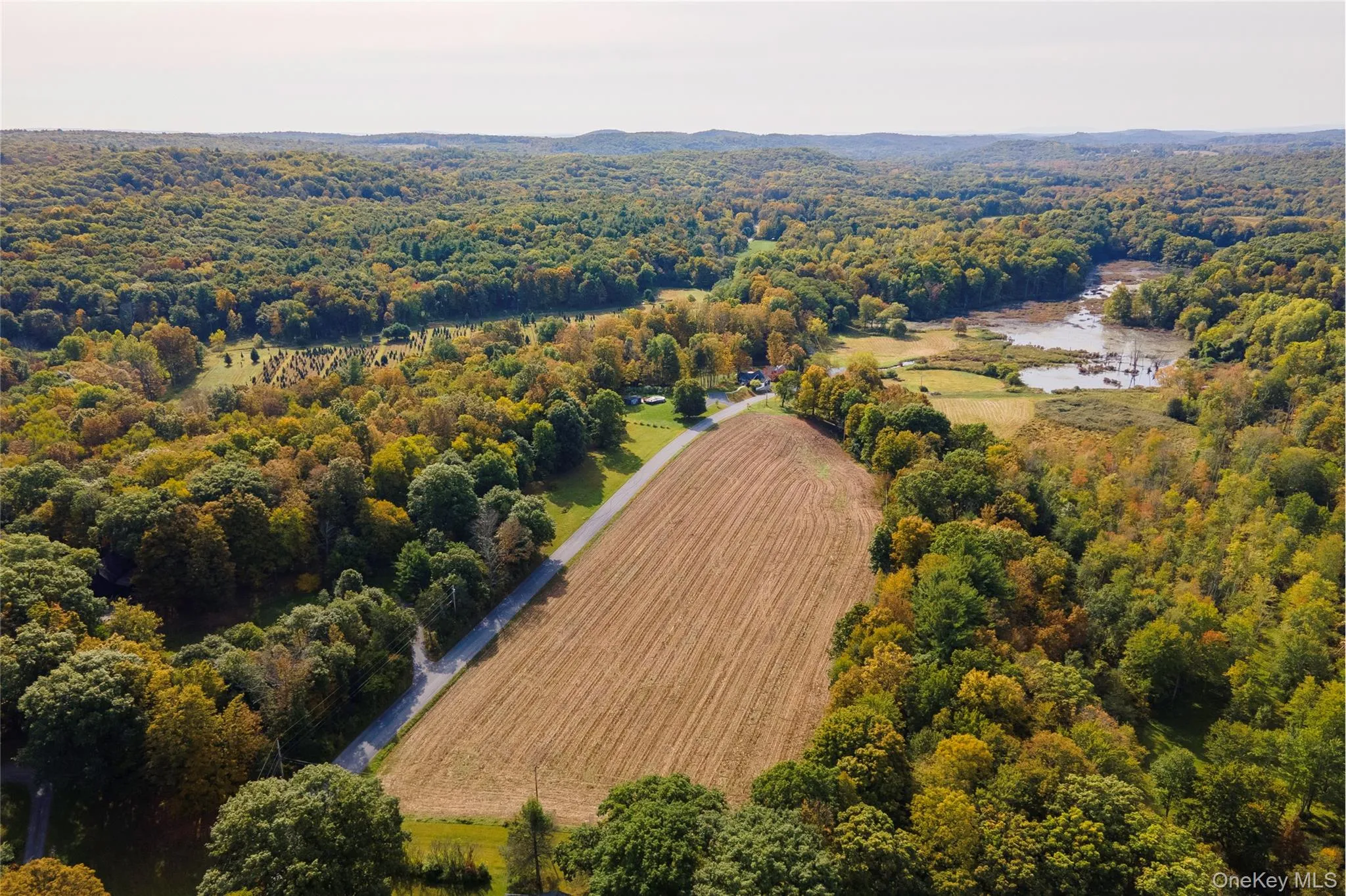 View of rural area with farmland and a nearby body of water View of rural area with farmland and a nearby body of water