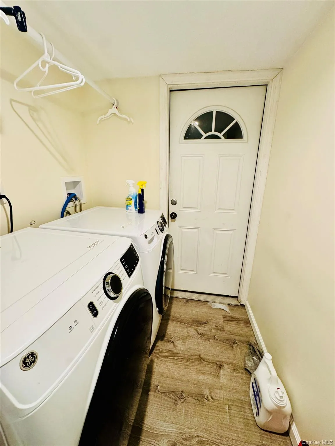 Laundry area featuring washing machine and clothes dryer and light wood-style flooring Laundry area featuring washing machine and clothes dryer and light wood-style flooring