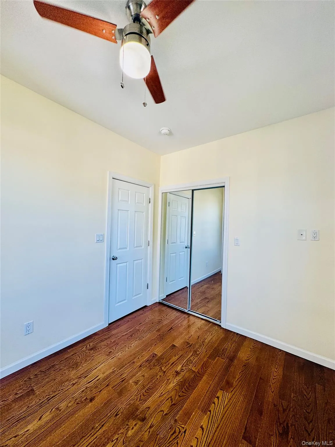 Unfurnished bedroom featuring a closet, wood finished floors, and ceiling fan Unfurnished bedroom featuring a closet, wood finished floors, and ceiling fan