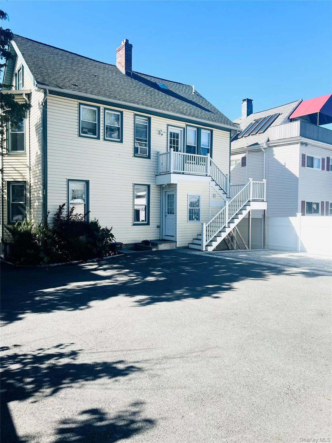 View of front of home featuring a chimney, stairway, and roof with shingles View of front of home featuring a chimney, stairway, and roof with shingles