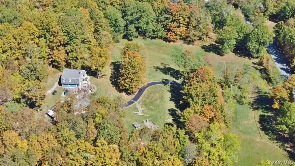 Aerial view of property and surrounding area with a heavily wooded area Aerial view of property and surrounding area with a heavily wooded area