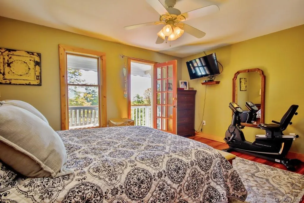 Bedroom with wood finished floors, access to exterior, and ceiling fan Bedroom with wood finished floors, access to exterior, and ceiling fan