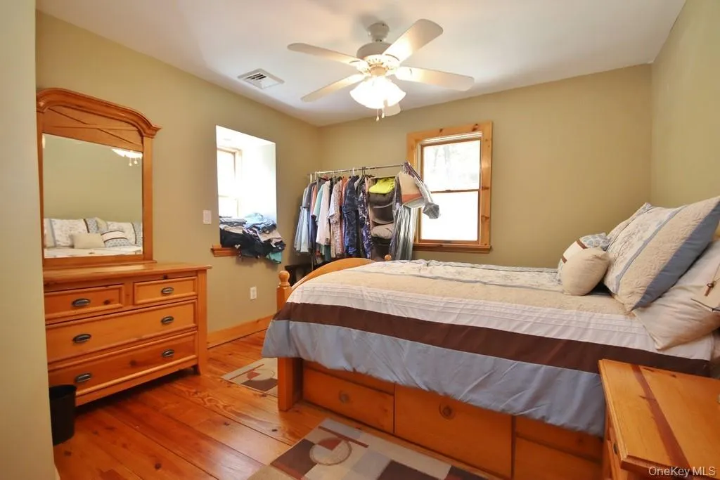 Bedroom featuring light wood-type flooring and a ceiling fan Bedroom featuring light wood-type flooring and a ceiling fan