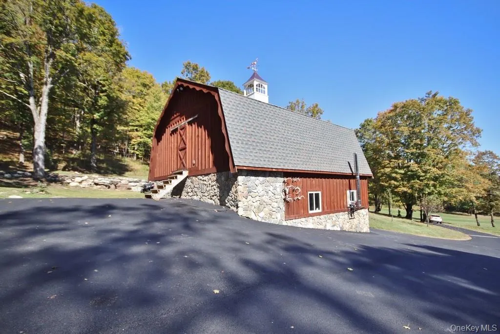 View of side of property featuring a gambrel roof, a barn, and an outdoor structure View of side of property featuring a gambrel roof, a barn, and an outdoor structure