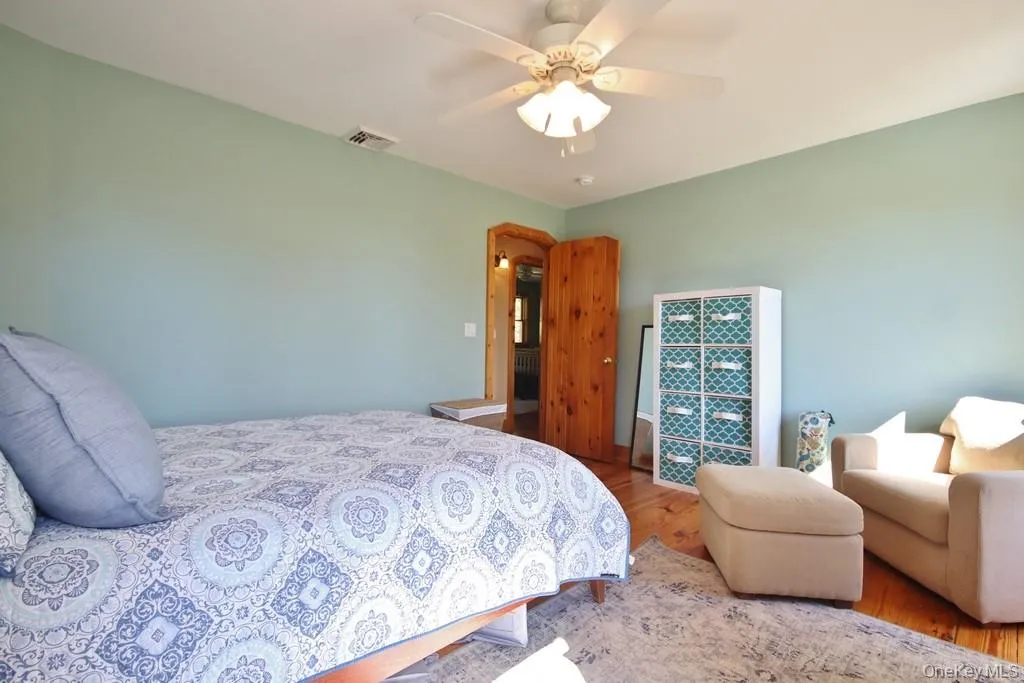 Bedroom with wood finished floors and a ceiling fan Bedroom with wood finished floors and a ceiling fan