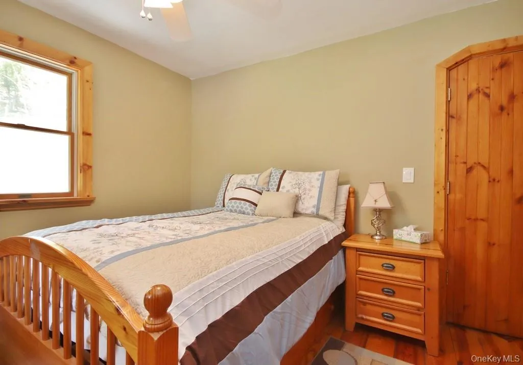 Bedroom with wood finished floors and ceiling fan Bedroom with wood finished floors and ceiling fan