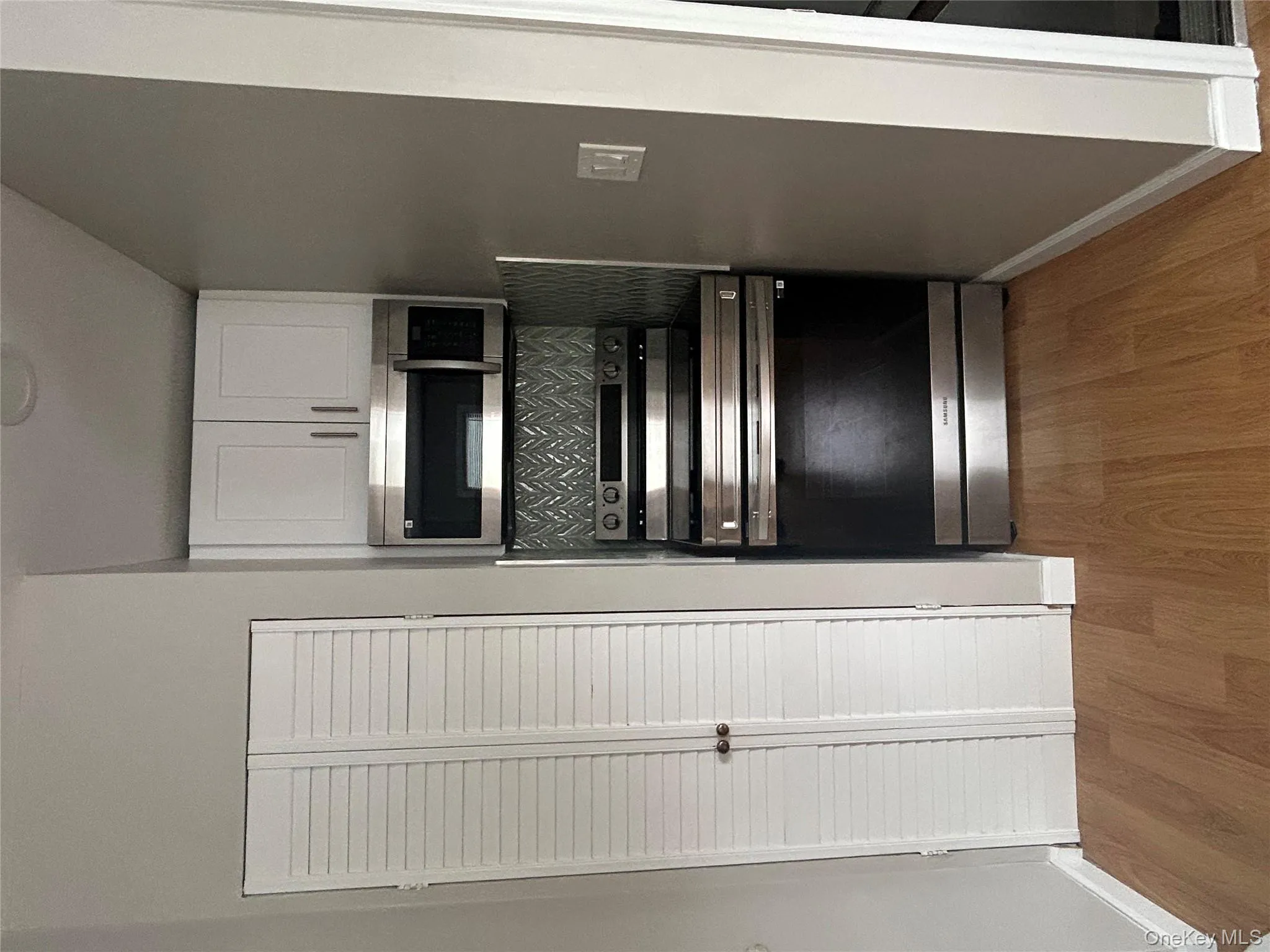 Kitchen with stainless steel range, light wood-type flooring, and white cabinetry Kitchen with stainless steel range, light wood-type flooring, and white cabinetry