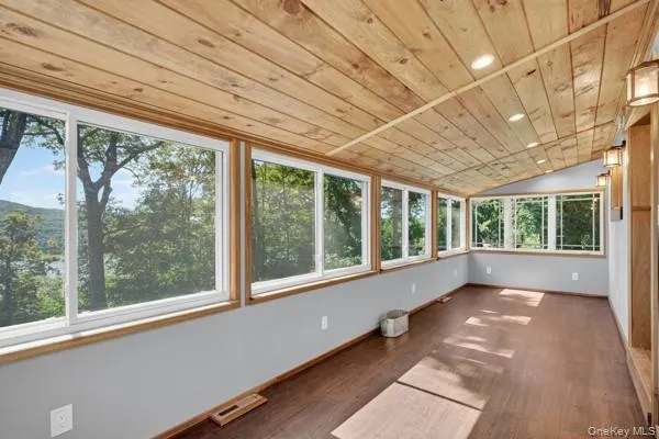 Unfurnished sunroom featuring lofted ceiling, wood ceiling, recessed lighting, and wood finished floors Unfurnished sunroom featuring lofted ceiling, wood ceiling, recessed lighting, and wood finished floors