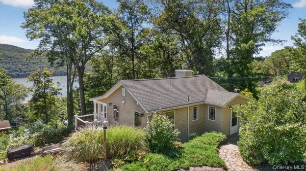 View of front of house with a chimney, view of scattered trees, and a shingled roof View of front of house with a chimney, view of scattered trees, and a shingled roof