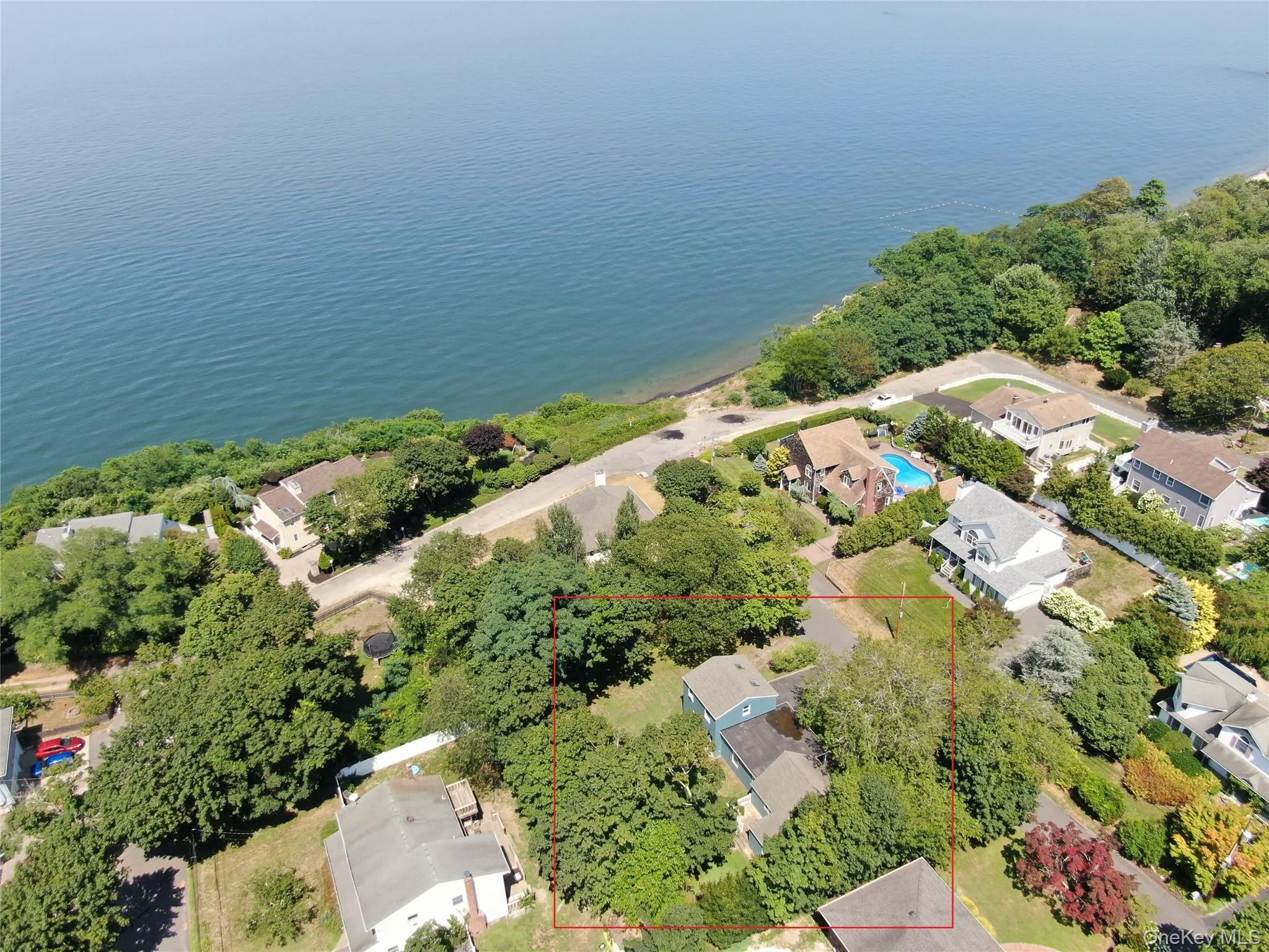 Aerial view of residential area featuring property boundaries highlighted and a nearby body of water Aerial view of residential area featuring property boundaries highlighted and a nearby body of water