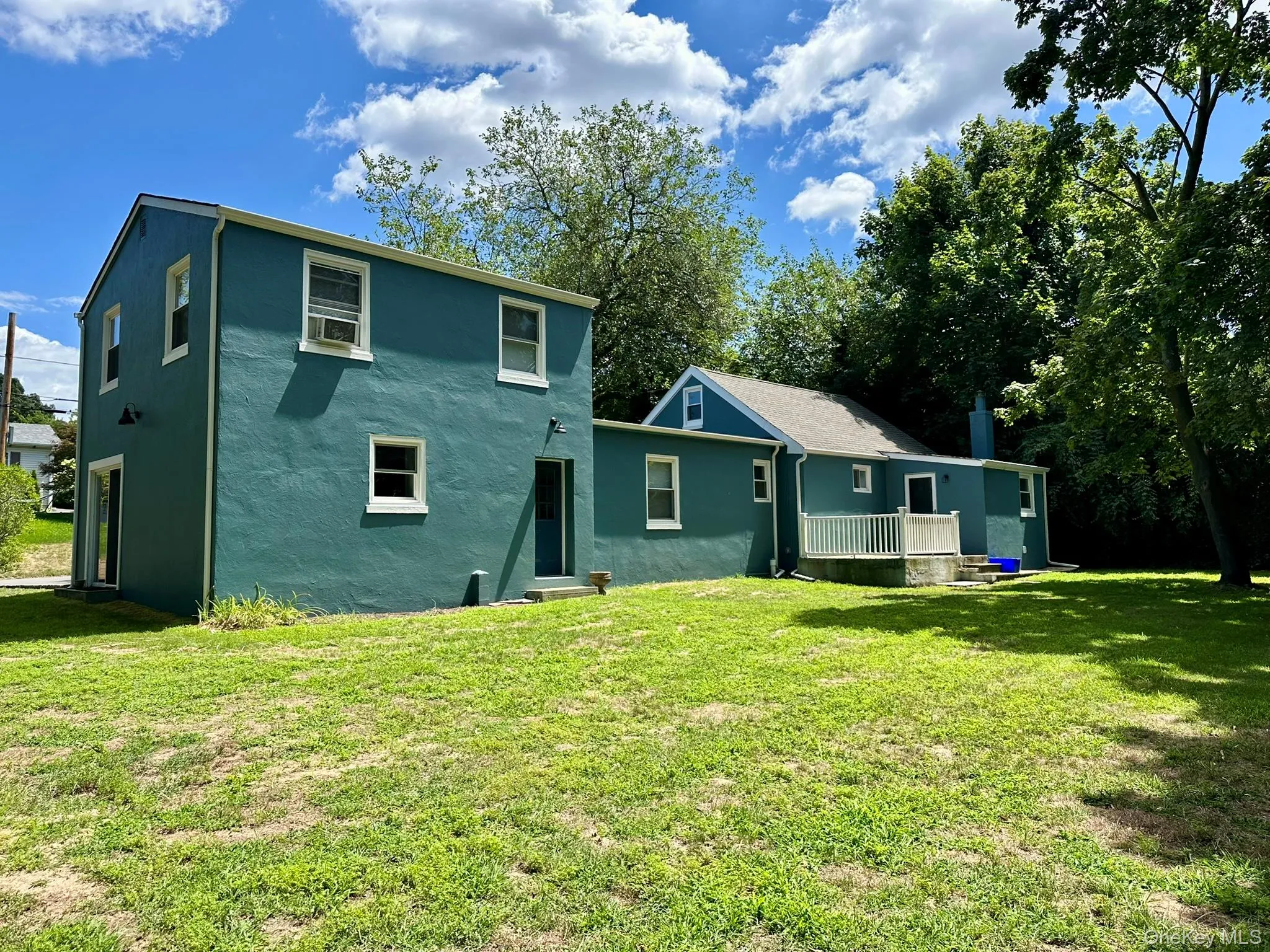 Rear view of property with a lawn and stucco siding Rear view of property with a lawn and stucco siding