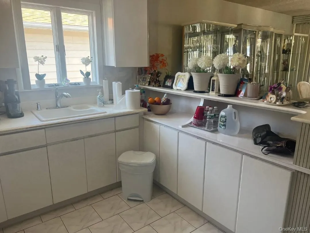 Kitchen with light countertops, white cabinets, and light tile patterned floors Kitchen with light countertops, white cabinets, and light tile patterned floors