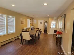 Conference area featuring recessed lighting, dark wood finished floors, and baseboard heating Conference area featuring recessed lighting, dark wood finished floors, and baseboard heating