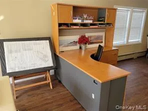 Office area featuring dark wood-type flooring and a baseboard radiator Office area featuring dark wood-type flooring and a baseboard radiator