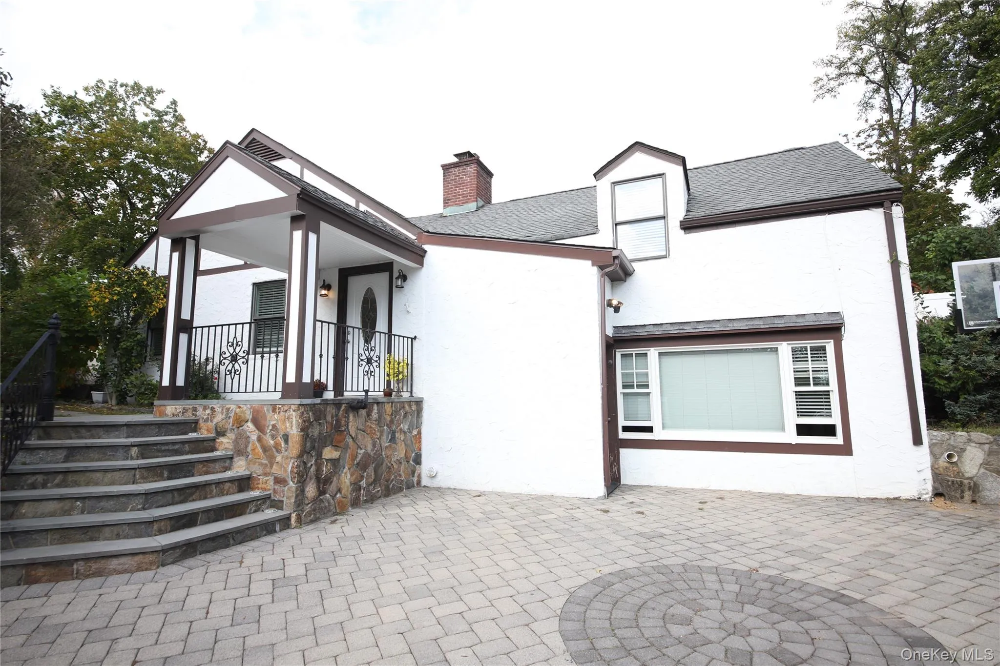 Rear view of property with stucco siding, a chimney, and a shingled roof Rear view of property with stucco siding, a chimney, and a shingled roof
