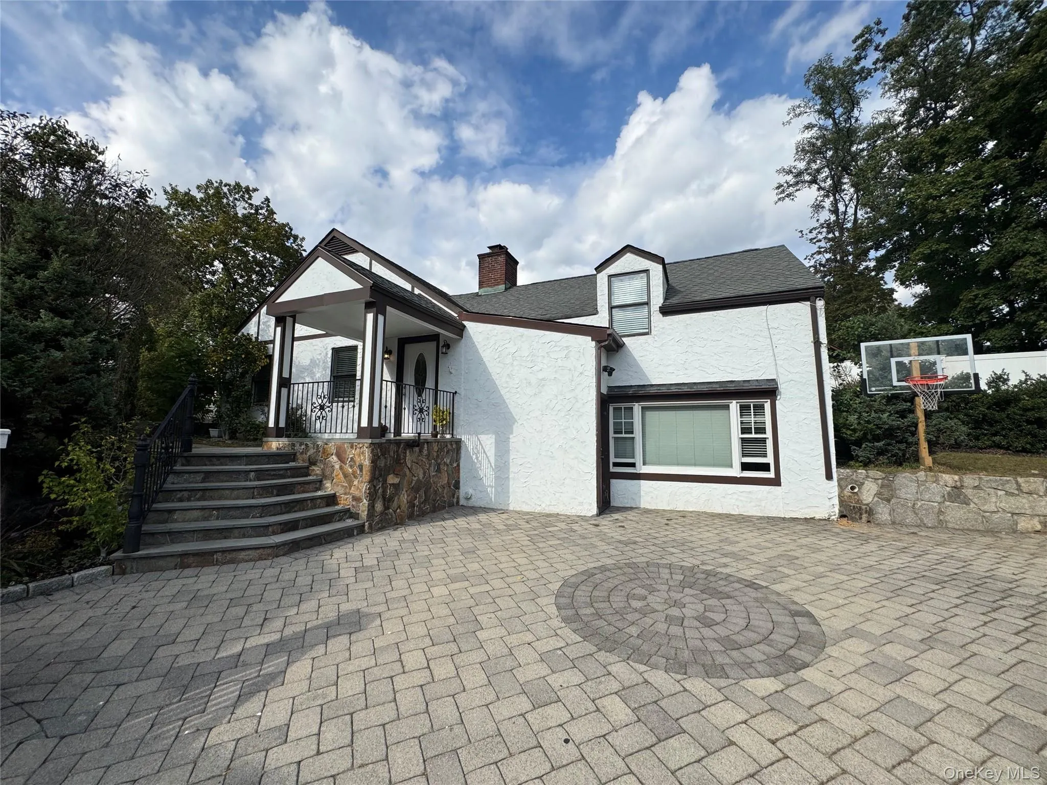 View of front of property featuring stucco siding, a chimney, and a patio area View of front of property featuring stucco siding, a chimney, and a patio area