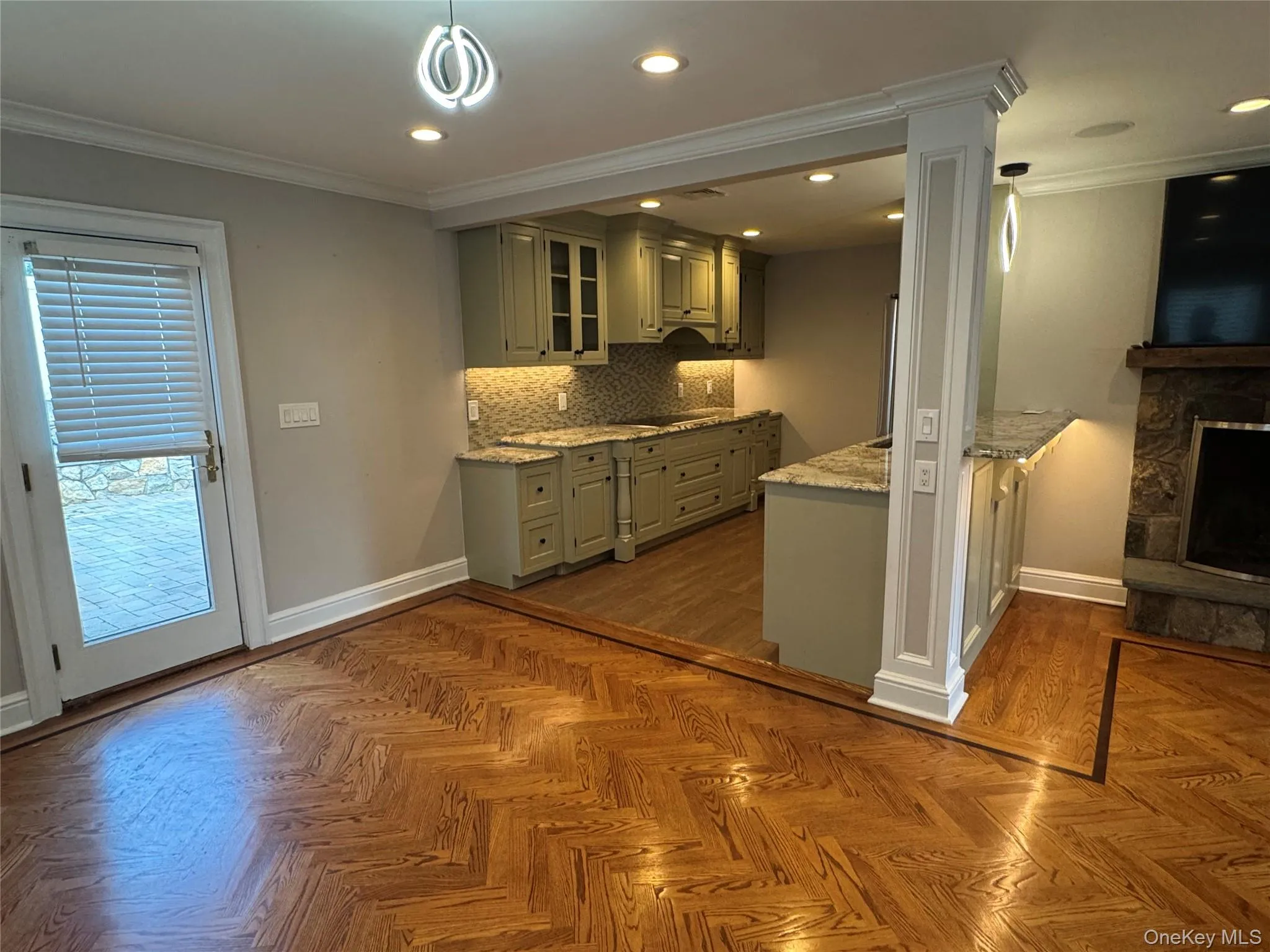 Kitchen featuring ornamental molding, backsplash, light stone counters, recessed lighting, and decorative light fixtures Kitchen featuring ornamental molding, backsplash, light stone counters, recessed lighting, and decorative light fixtures