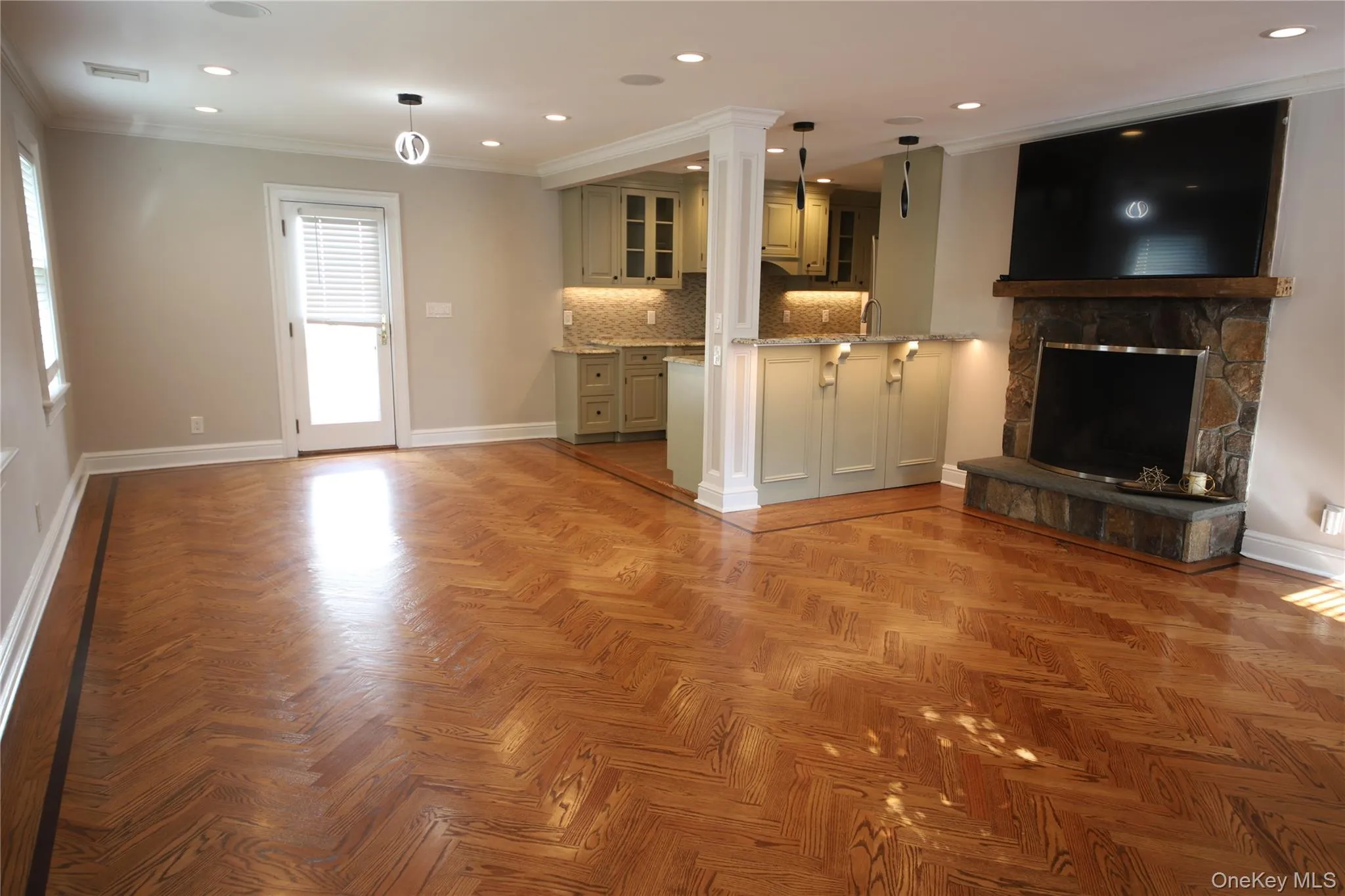 Unfurnished living room featuring crown molding, recessed lighting, and a stone fireplace Unfurnished living room featuring crown molding, recessed lighting, and a stone fireplace