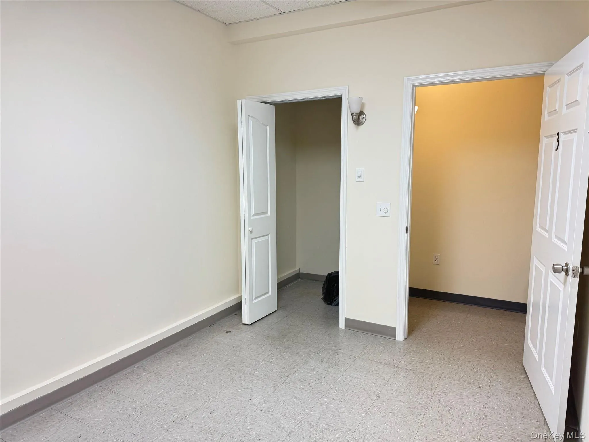 Unfurnished bedroom with light floors and a drop ceiling Unfurnished bedroom with light floors and a drop ceiling