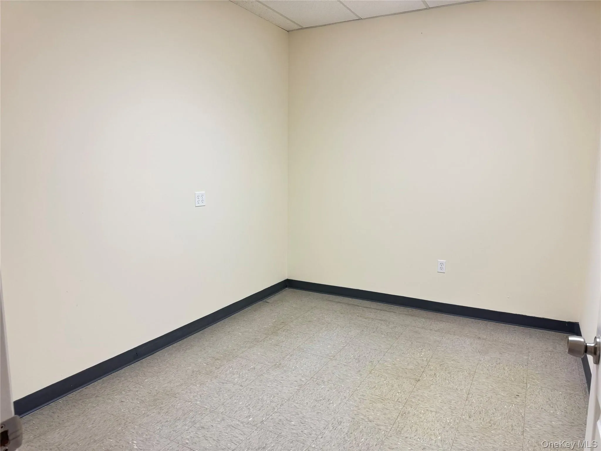 Empty room with a paneled ceiling and light floors Empty room with a paneled ceiling and light floors