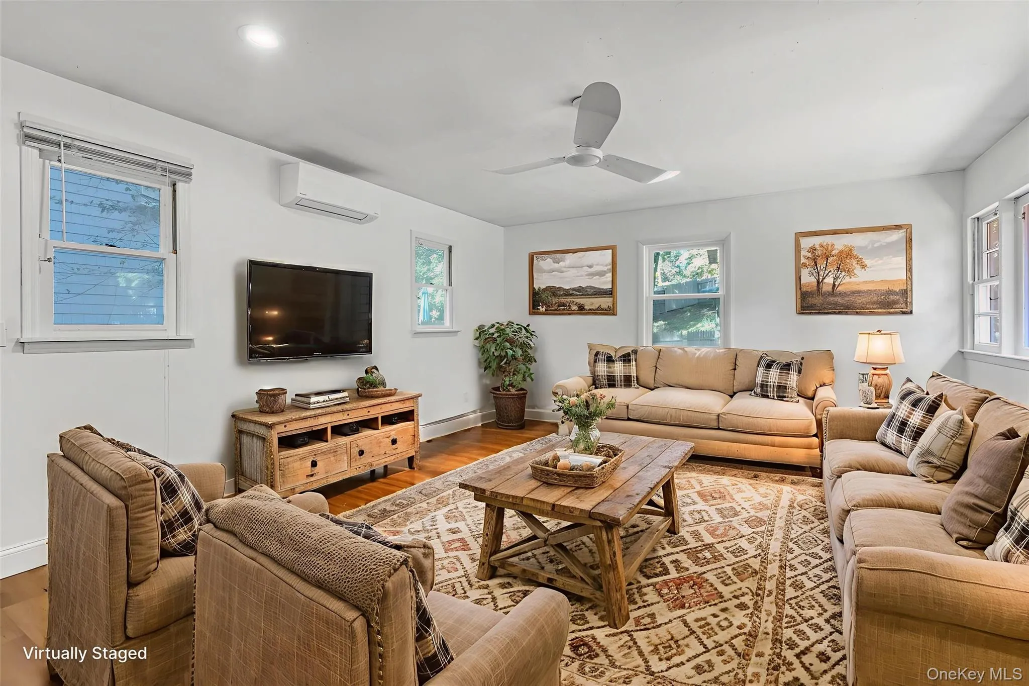 Family room featuring wood finished floors, ceiling fan, and a wall mounted ductless air conditioner Family room featuring wood finished floors, ceiling fan, and a wall mounted ductless air conditioner