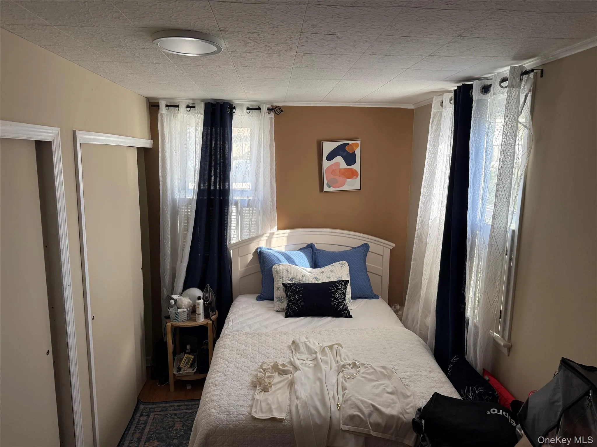 Bedroom with a closet, wood finished floors, and crown molding Bedroom with a closet, wood finished floors, and crown molding