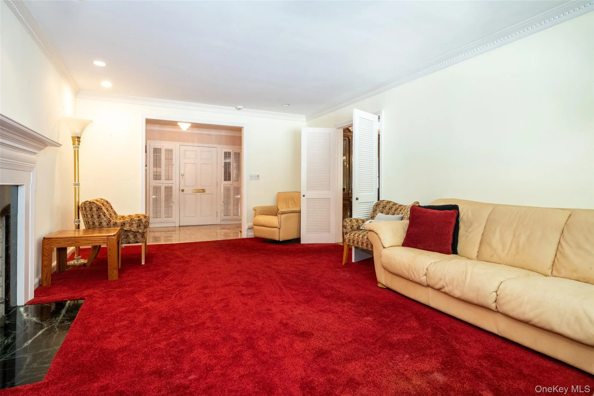 Carpeted living area with crown molding, a high end fireplace, and recessed lighting Carpeted living area with crown molding, a high end fireplace, and recessed lighting