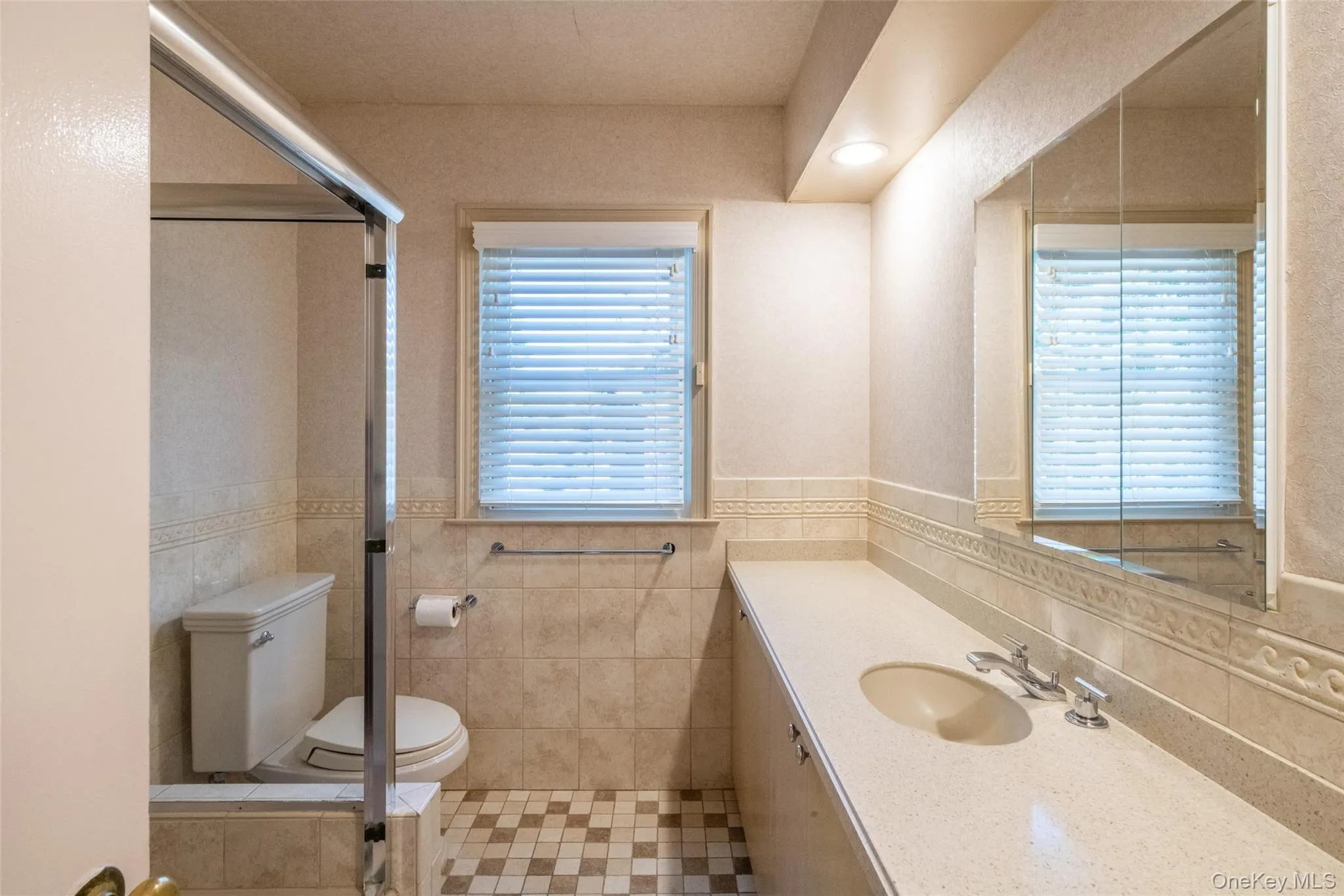 Bathroom featuring vanity, a stall shower, tile walls, and light tile patterned flooring Bathroom featuring vanity, a stall shower, tile walls, and light tile patterned flooring