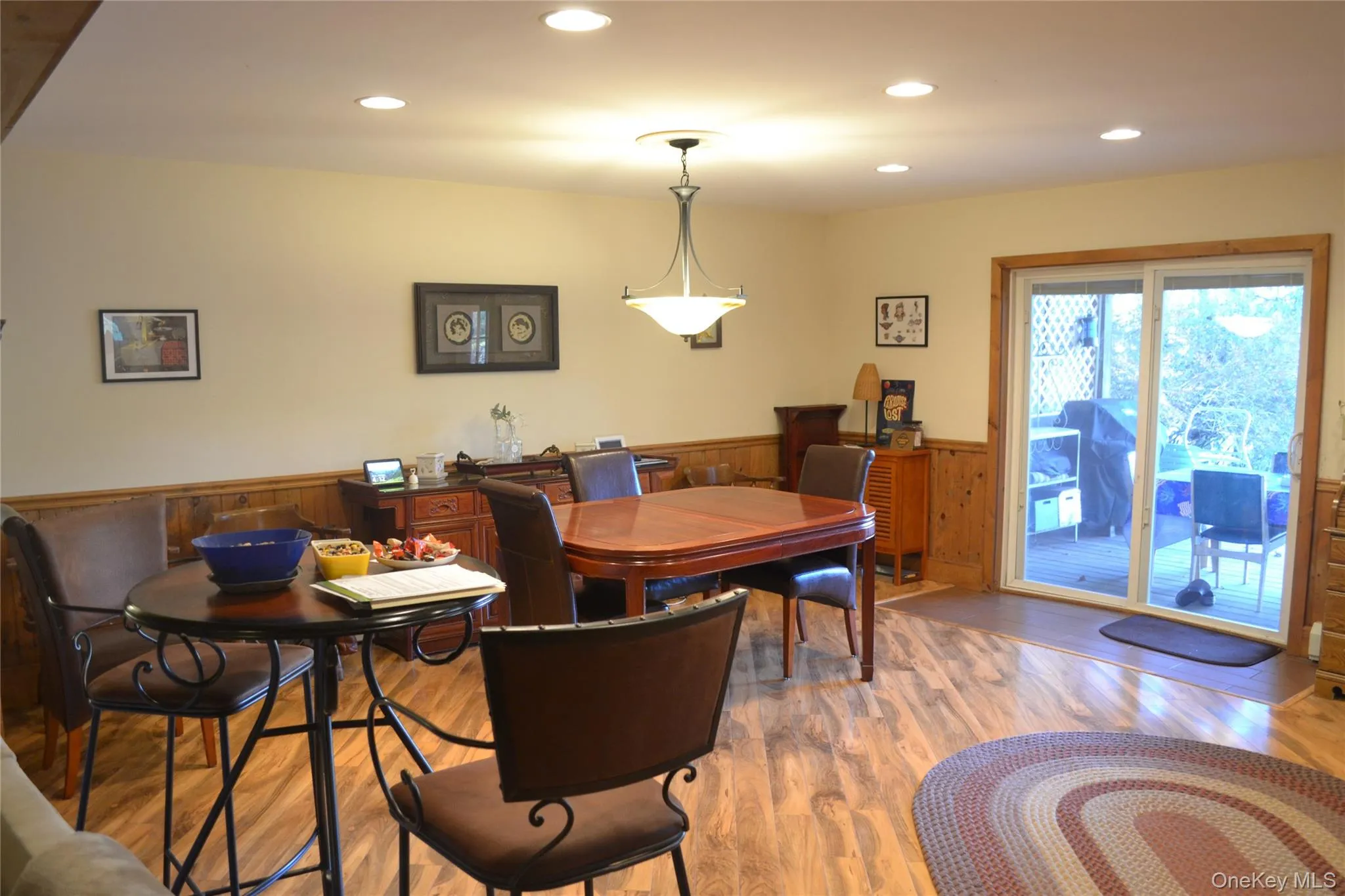 Dining room featuring recessed lighting, a wainscoted wall, wood walls, and wood finished floors Dining room featuring recessed lighting, a wainscoted wall, wood walls, and wood finished floors