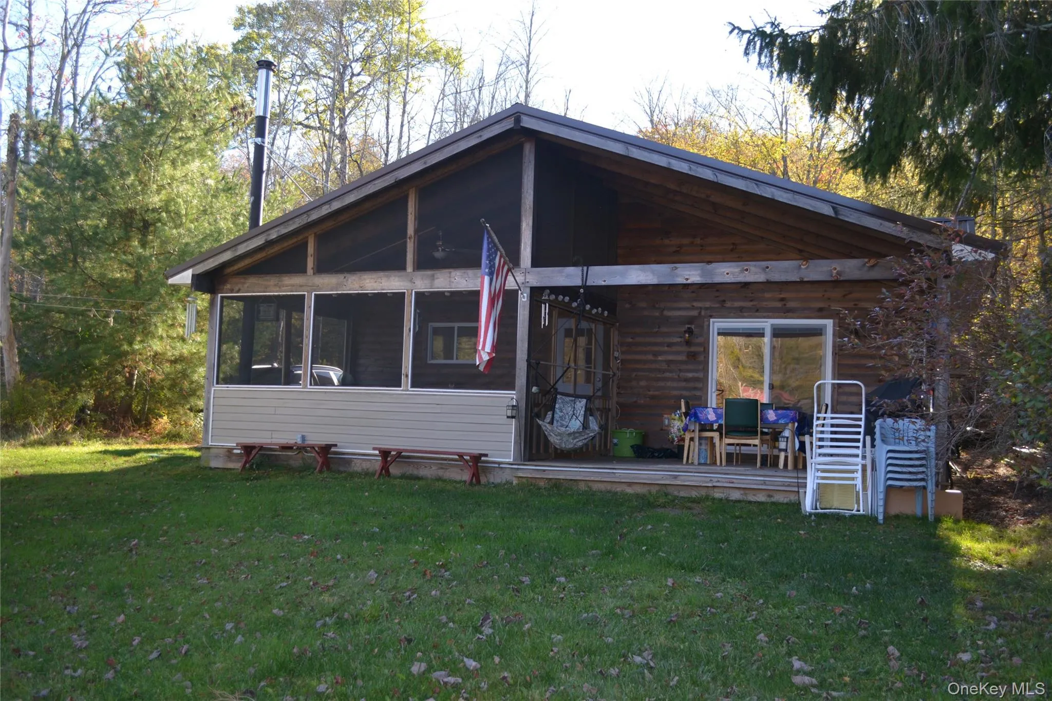 View of front of house featuring a deck, a front yard, and a sunroom View of front of house featuring a deck, a front yard, and a sunroom