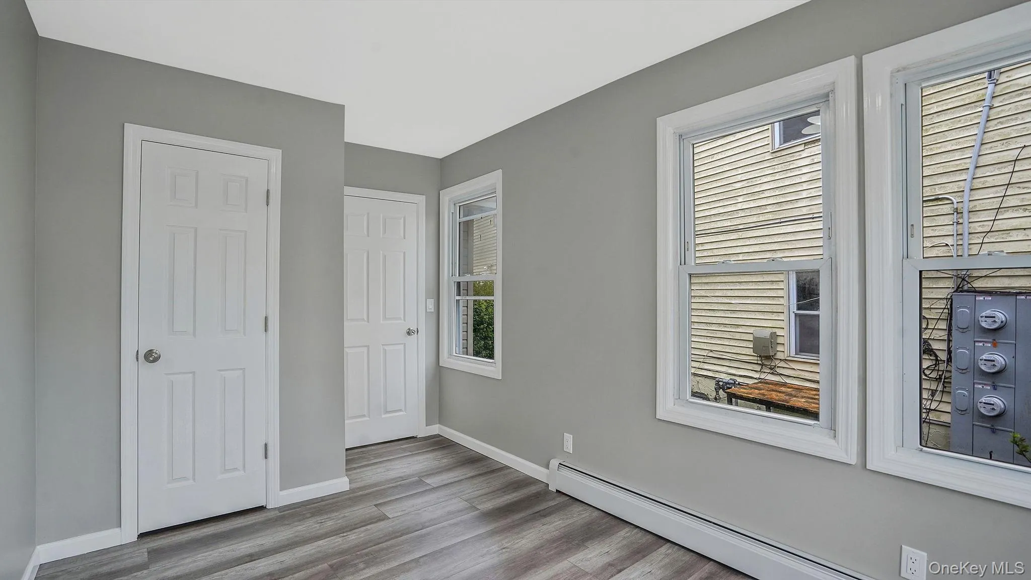 Unfurnished bedroom featuring a baseboard radiator and light wood-style floors Unfurnished bedroom featuring a baseboard radiator and light wood-style floors