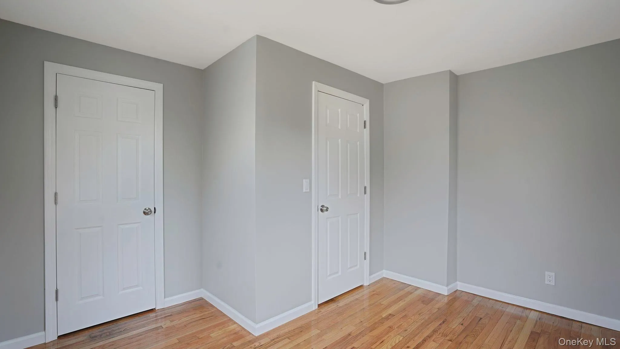 Unfurnished bedroom with baseboards and light wood finished floors Unfurnished bedroom with baseboards and light wood finished floors