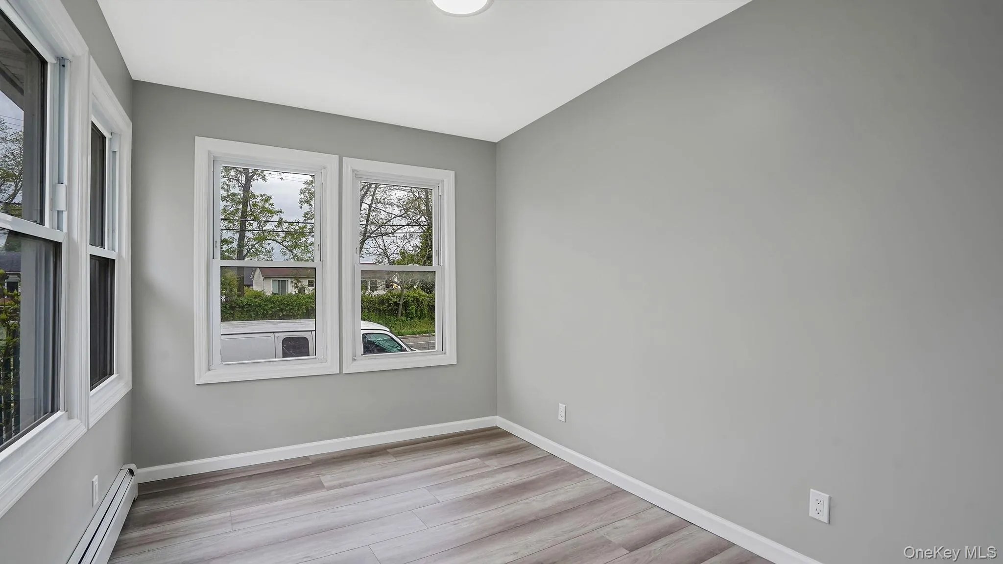 Spare room with a baseboard radiator and light wood-style floors Spare room with a baseboard radiator and light wood-style floors
