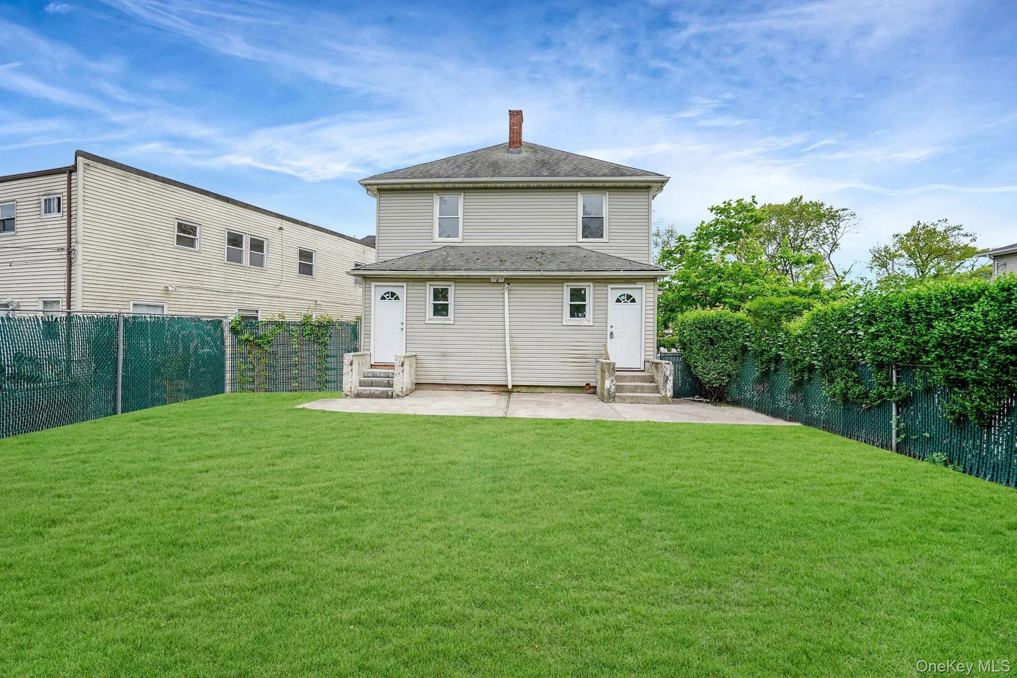 Rear view of house featuring a patio, a fenced backyard, a chimney, and entry steps Rear view of house featuring a patio, a fenced backyard, a chimney, and entry steps