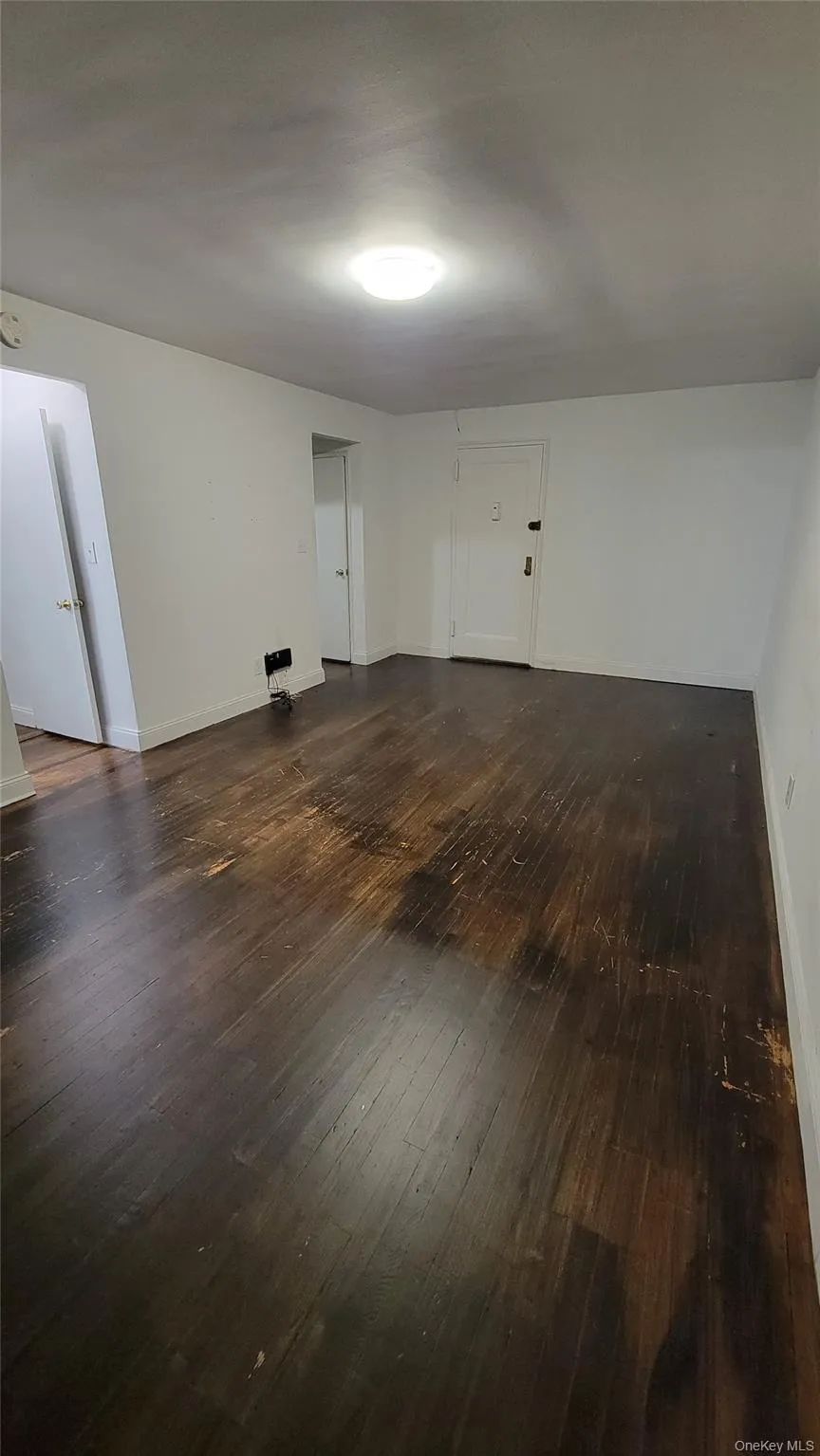 Empty room with dark wood finished floors and baseboards Empty room with dark wood finished floors and baseboards