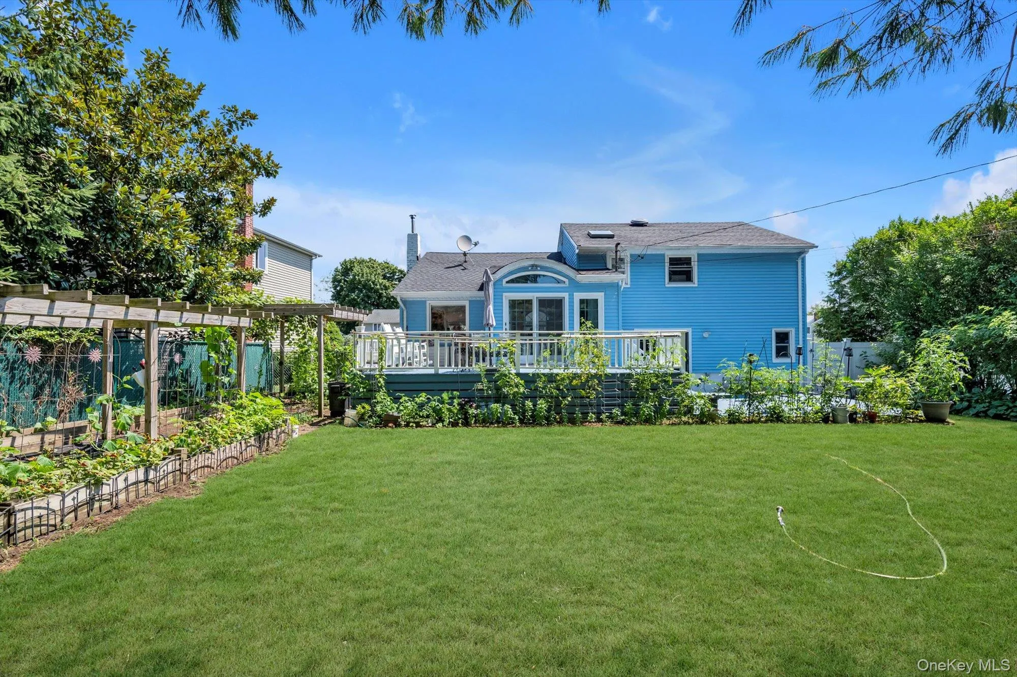 View of yard featuring a deck and a garden View of yard featuring a deck and a garden
