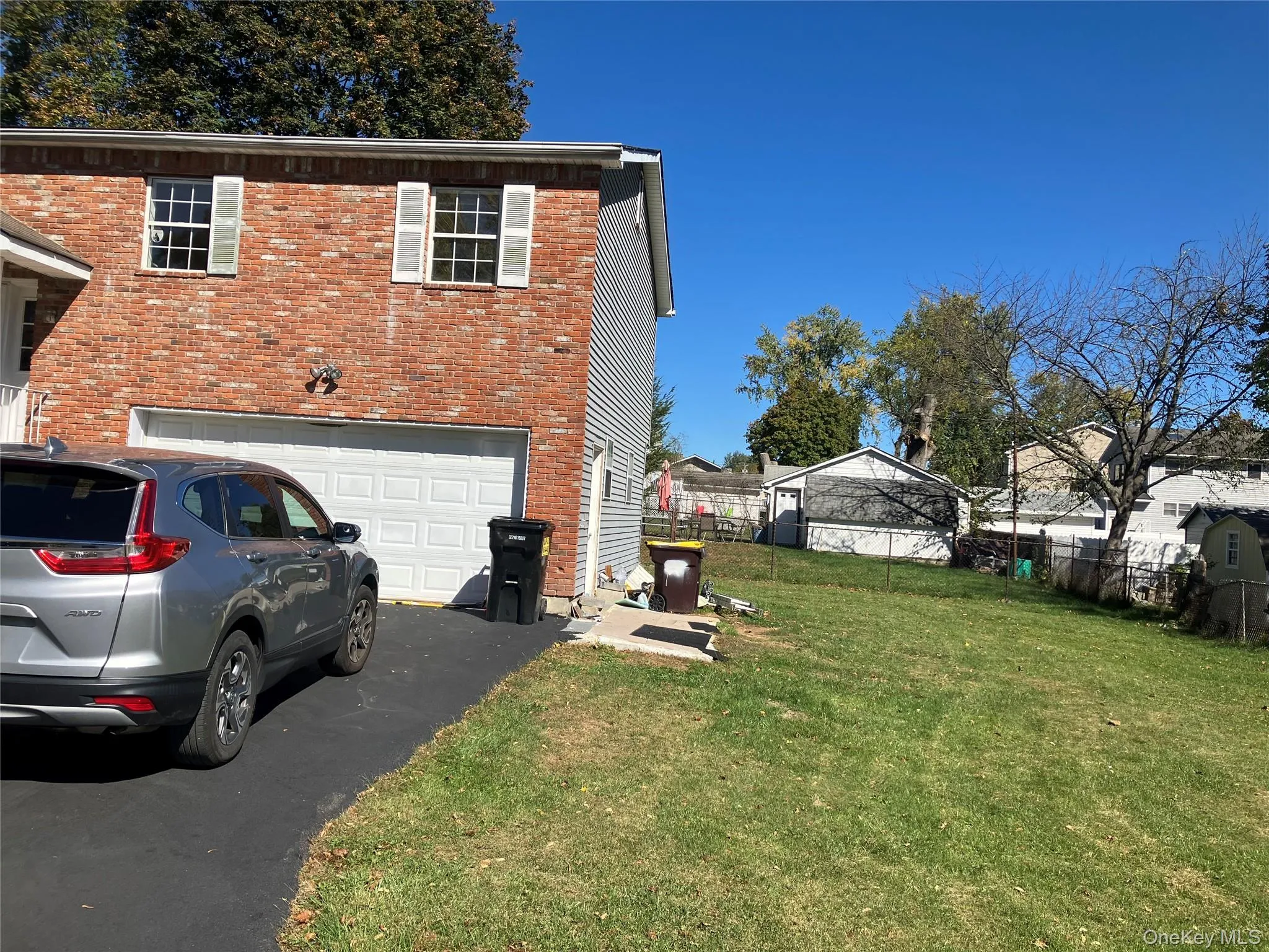 View of side of home with asphalt driveway, brick siding, and a garage View of side of home with asphalt driveway, brick siding, and a garage