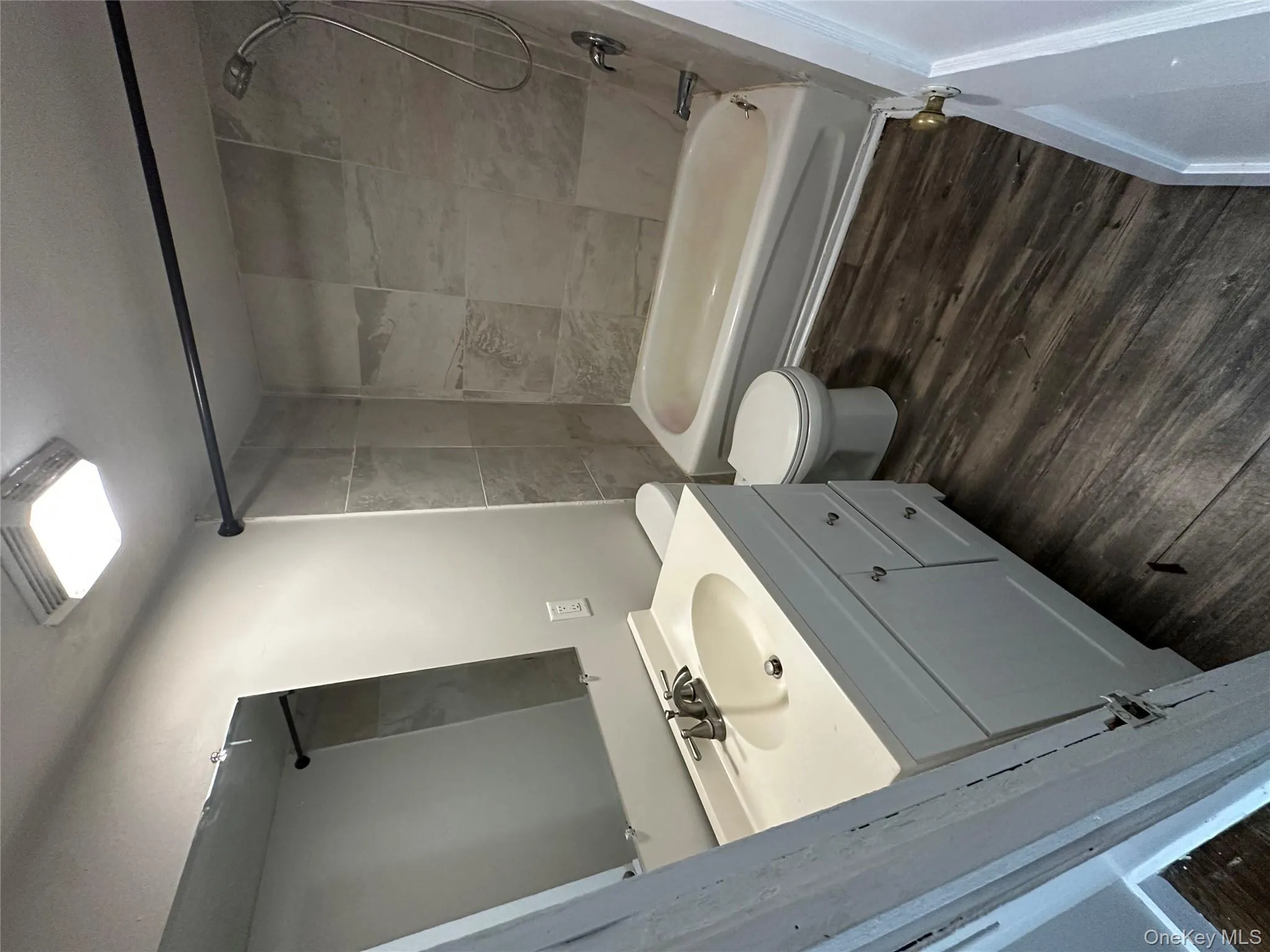 Full bath featuring washtub / shower combination, vanity, and dark wood-style flooring Full bath featuring washtub / shower combination, vanity, and dark wood-style flooring