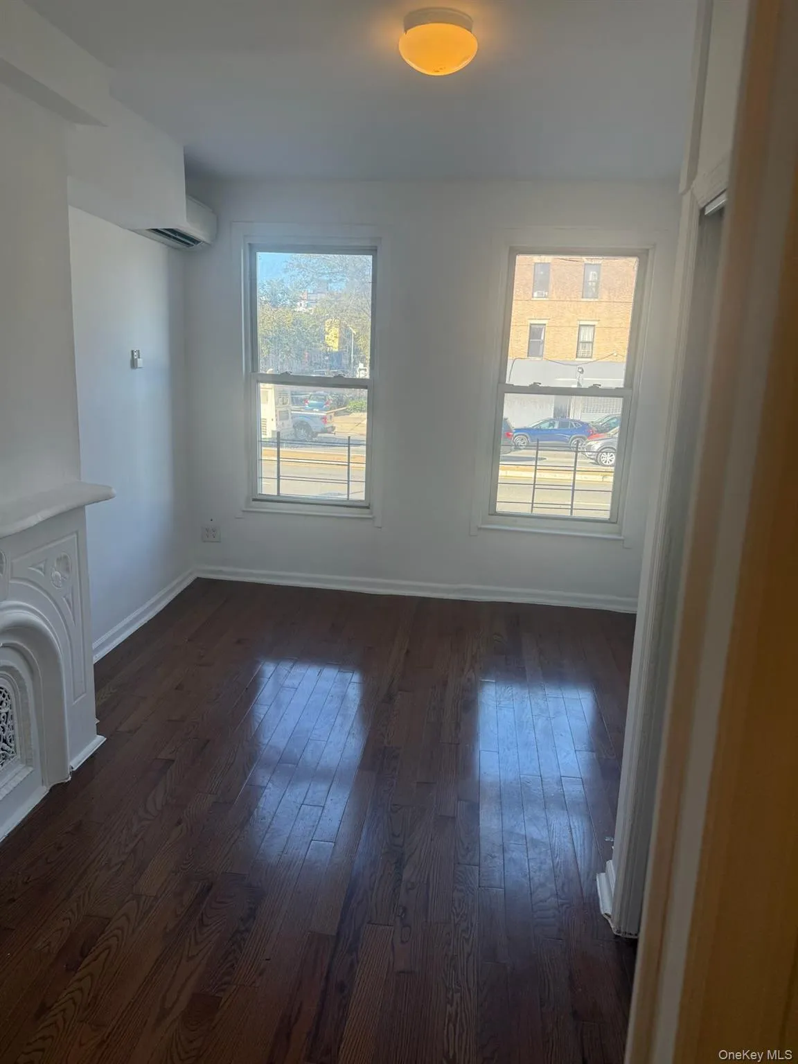 Unfurnished living room with healthy amount of natural light and dark wood-style flooring Unfurnished living room with healthy amount of natural light and dark wood-style flooring
