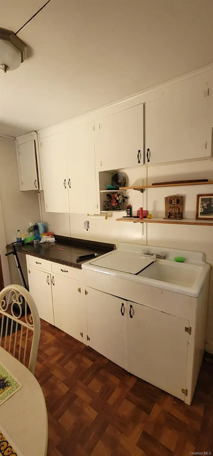 Kitchen featuring white cabinets and dark countertops Kitchen featuring white cabinets and dark countertops