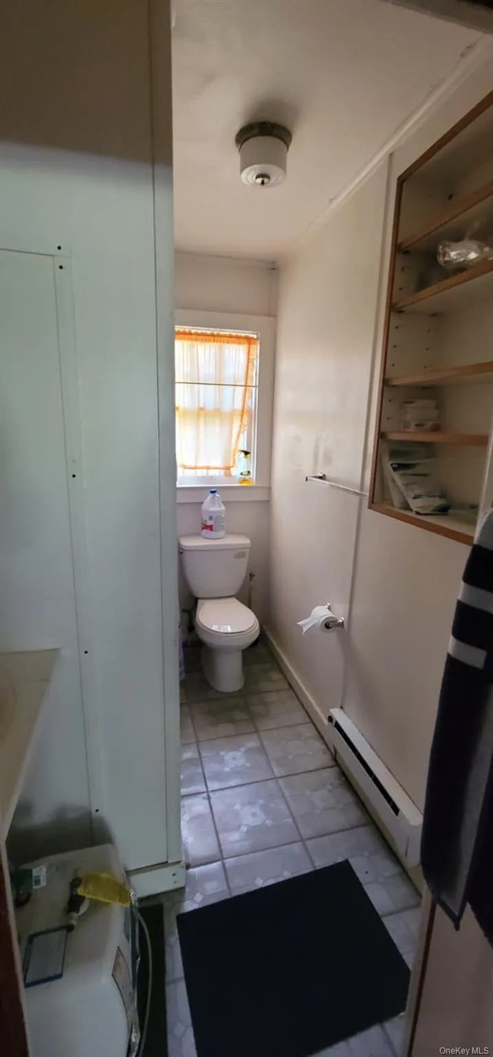 Bathroom featuring toilet and a baseboard radiator Bathroom featuring toilet and a baseboard radiator