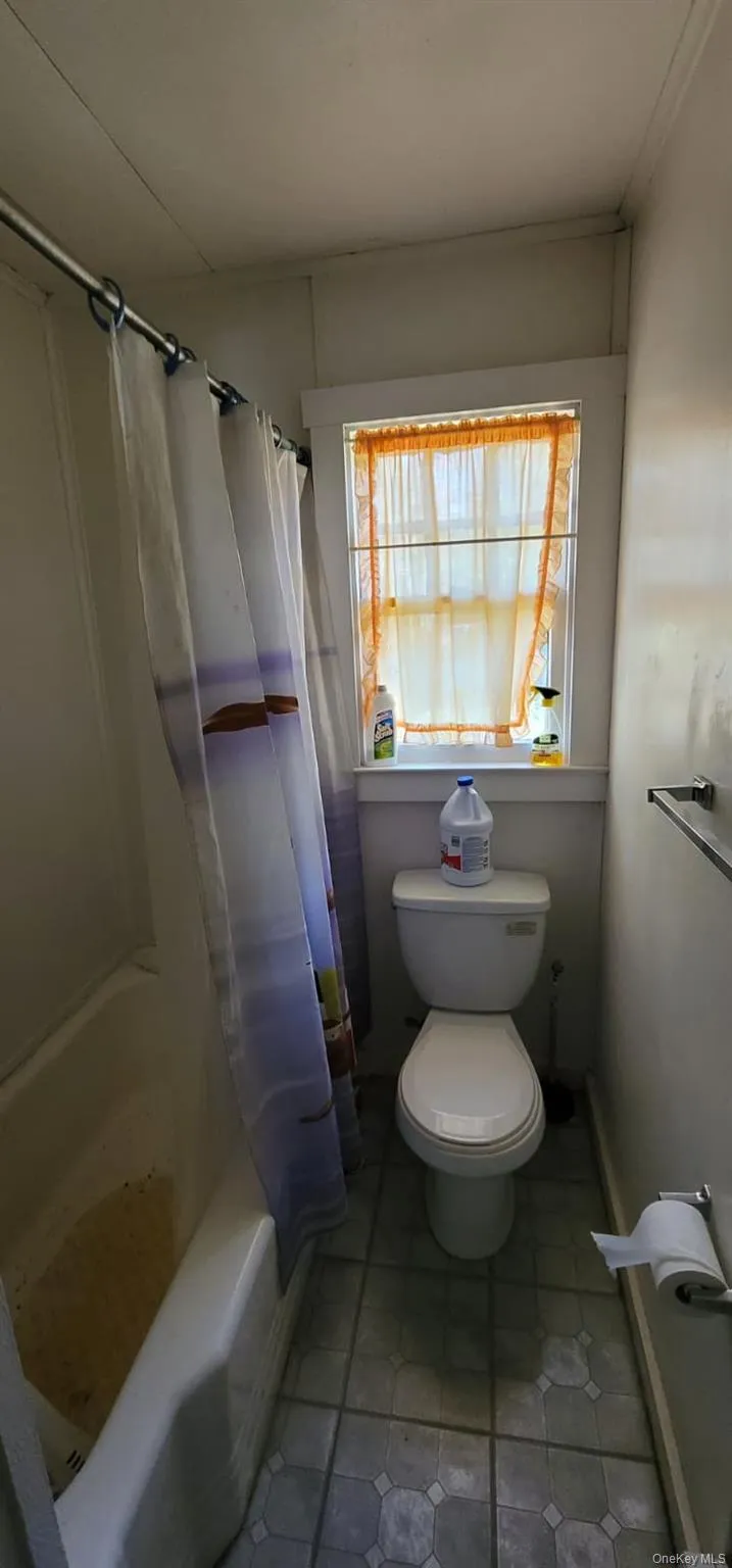 Full bathroom with shower / bathtub combination with curtain and light tile patterned floors Full bathroom with shower / bathtub combination with curtain and light tile patterned floors