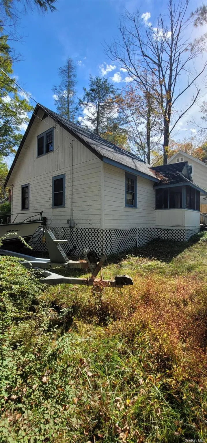 View of side of property featuring a sunroom and a deck View of side of property featuring a sunroom and a deck