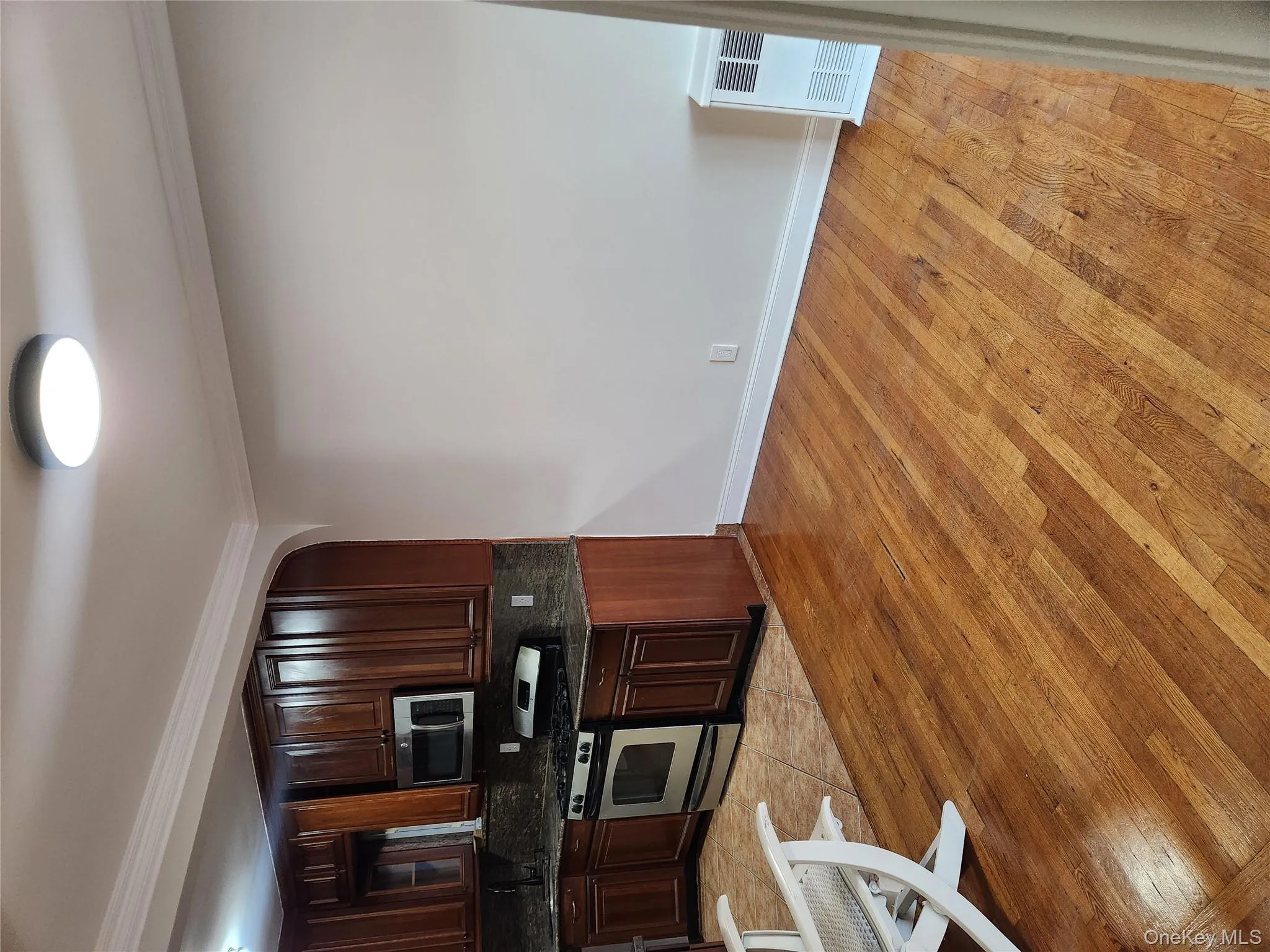 Kitchen with arched walkways, backsplash, light wood-type flooring, dark brown cabinetry, and stainless steel range Kitchen with arched walkways, backsplash, light wood-type flooring, dark brown cabinetry, and stainless steel range