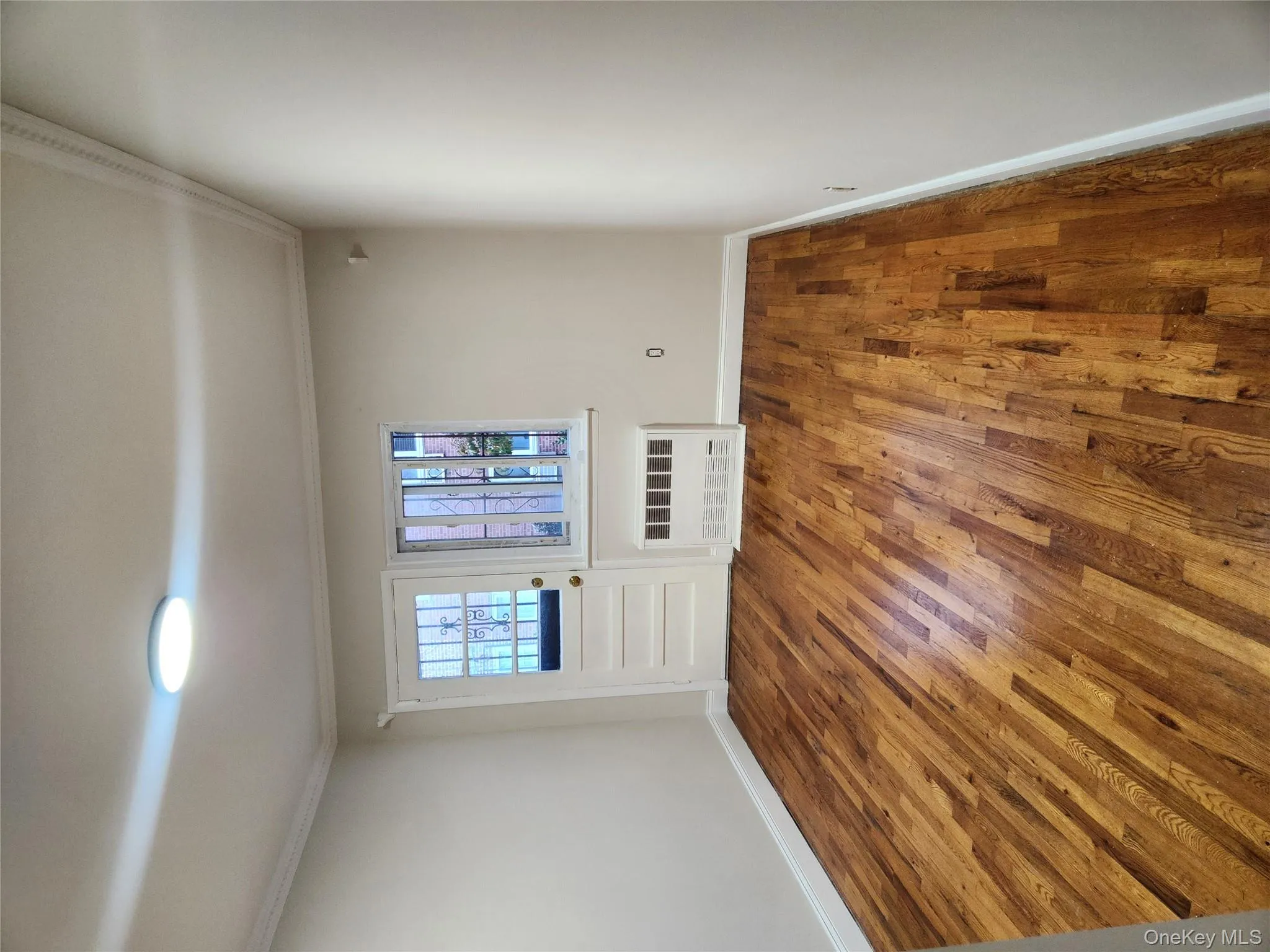 Unfurnished room with wood finished floors, radiator, and ornamental molding Unfurnished room with wood finished floors, radiator, and ornamental molding