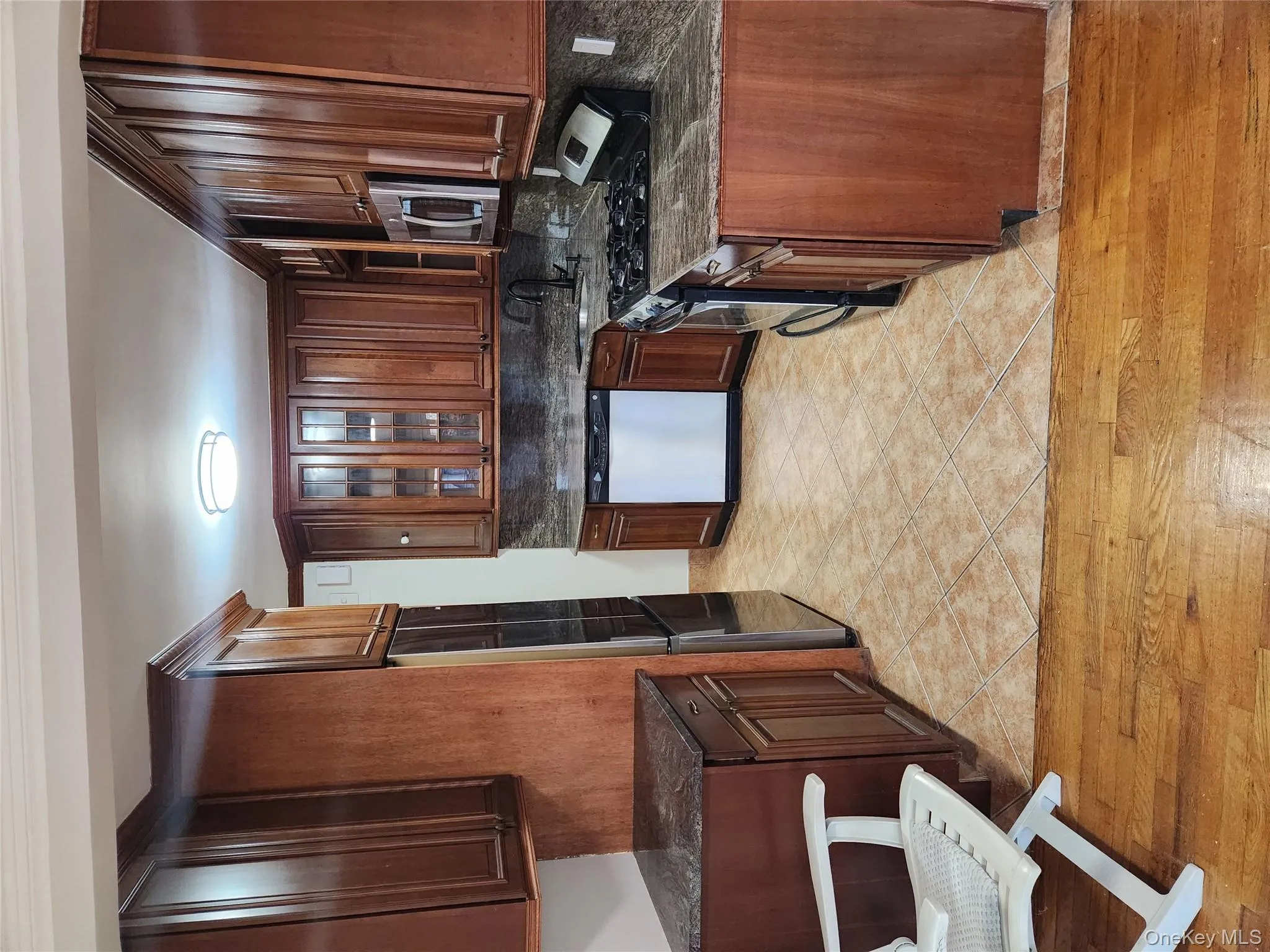 Kitchen featuring stove, dark stone countertops, glass insert cabinets, and dishwasher Kitchen featuring stove, dark stone countertops, glass insert cabinets, and dishwasher