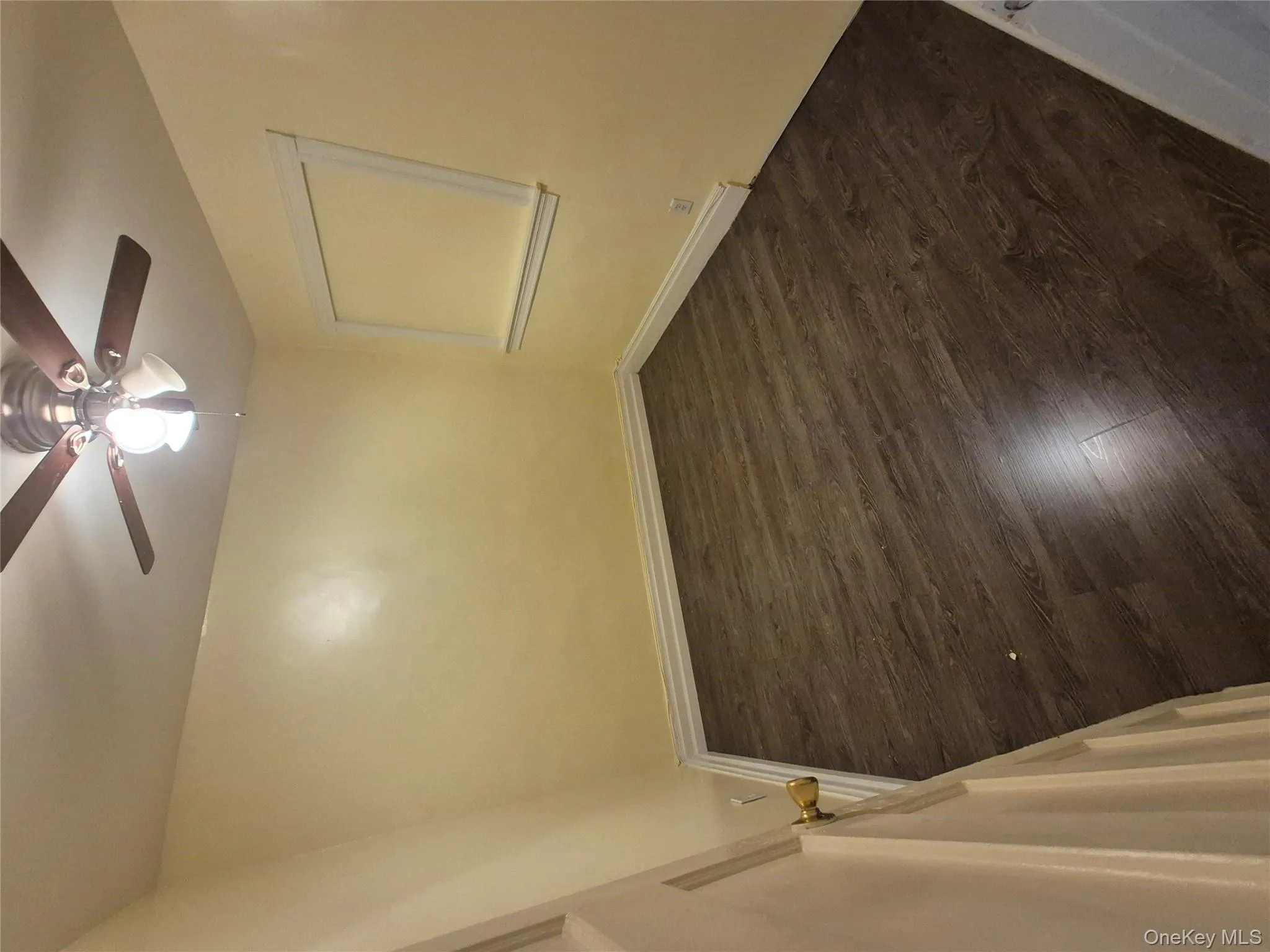 Empty room with dark wood-style flooring and a ceiling fan Empty room with dark wood-style flooring and a ceiling fan