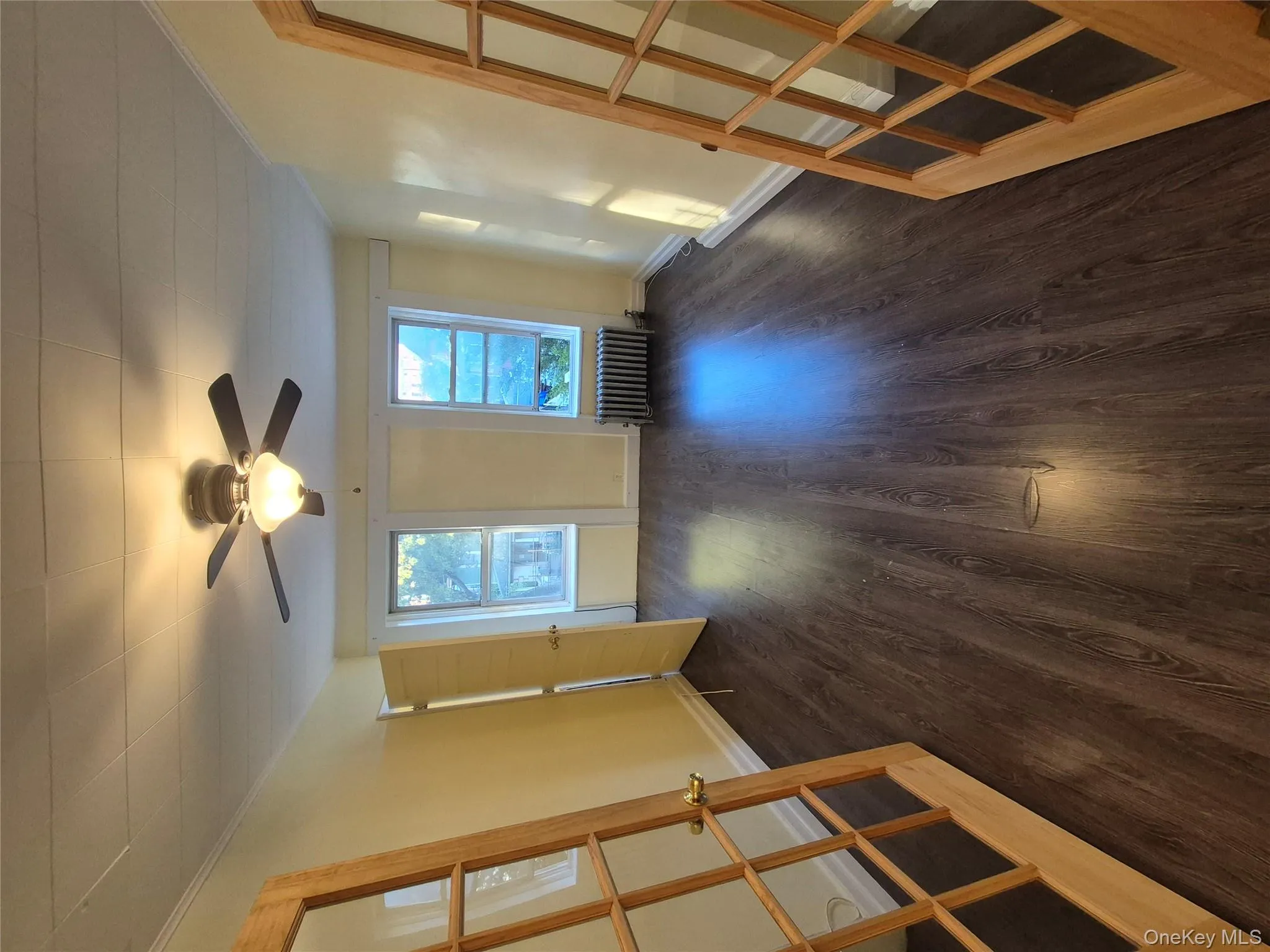 Unfurnished room with dark wood-type flooring, radiator, ceiling fan, and ornamental molding Unfurnished room with dark wood-type flooring, radiator, ceiling fan, and ornamental molding