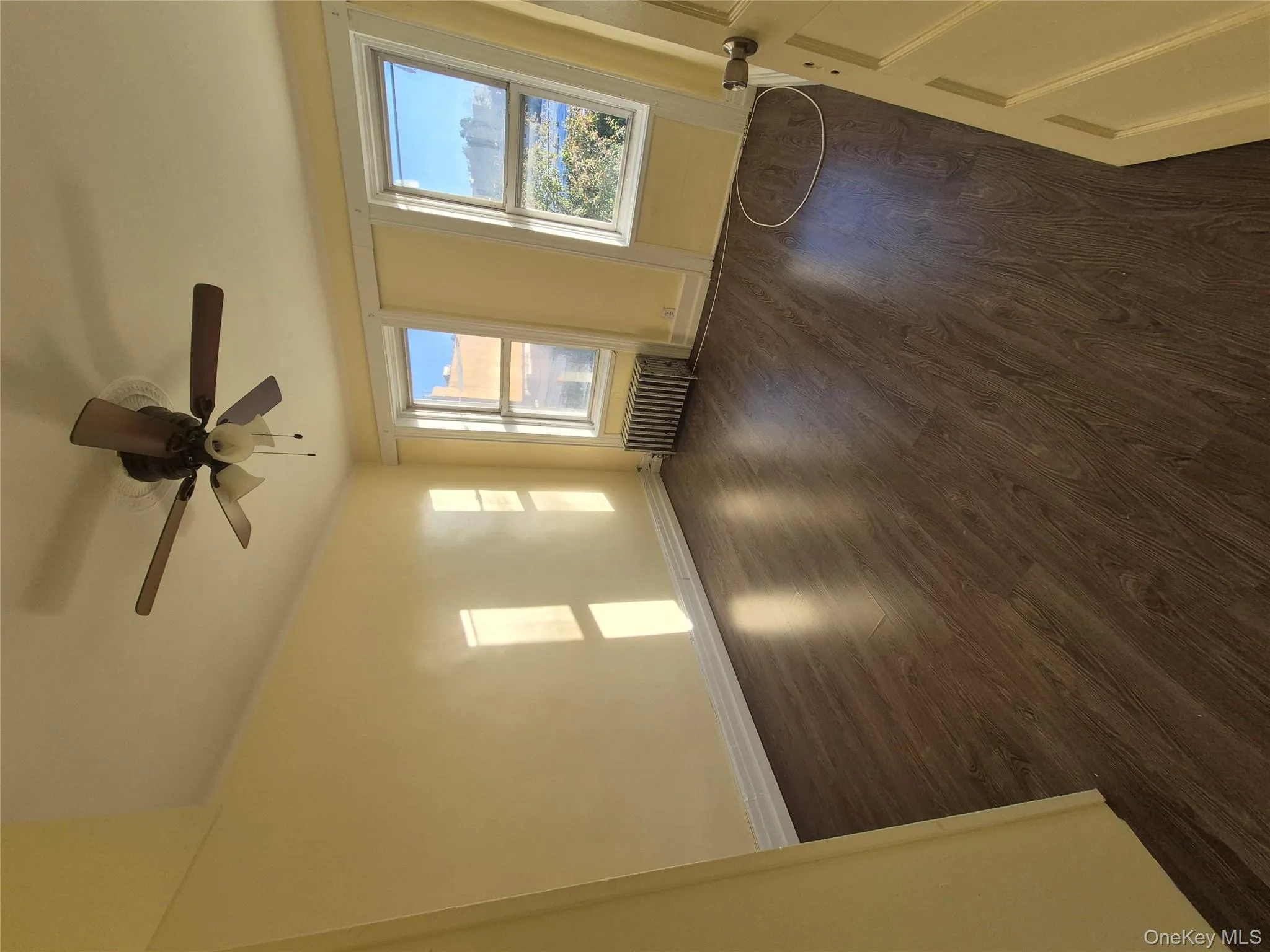 Empty room featuring dark wood-type flooring and radiator heating unit Empty room featuring dark wood-type flooring and radiator heating unit