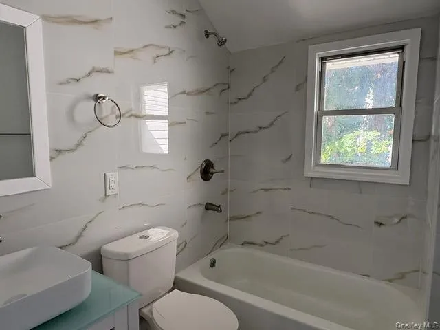 Full bath featuring shower / tub combination, vanity, and vaulted ceiling Full bath featuring shower / tub combination, vanity, and vaulted ceiling